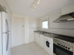 una cucina bianca con lavatrice e asciugatrice di Apartment Playsol-1 by Interhome a Calpe