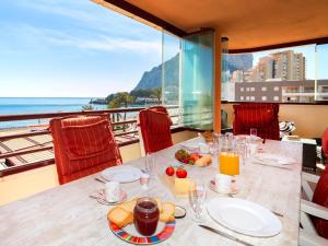 a table with plates of food and a view of the ocean at Apartment Zafiro 01 by Interhome in Calpe
