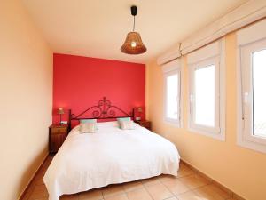 a bedroom with a white bed with a red wall at Apartment Las Fuentes by Interhome in Almuñécar