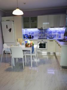 uma cozinha com uma mesa e cadeiras e um frigorífico em Alisahni Villa & Suite em Kato Daratso