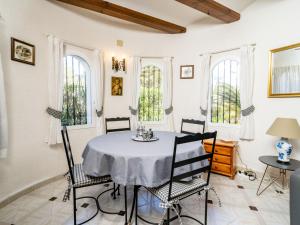 a dining room with a table and chairs and windows at Holiday Home Pinomar by Interhome in Benitachell