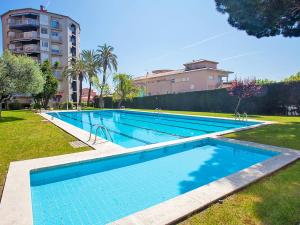 una gran piscina en un parque con un edificio en Apartment Edificio Blanqueries by Interhome, en Calella