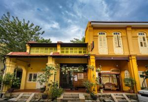 a yellow building with windows and plants in front of it at Spices Hotel in George Town