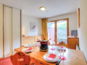 een eetkamer met een houten tafel en stoelen bij Apartment Bâtiment A-13 by Interhome in Le Corbier +21 foto's