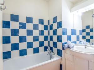 een badkamer met een blauwe en witte tegelmuur bij Apartment Bâtiment A-13 by Interhome in Le Corbier