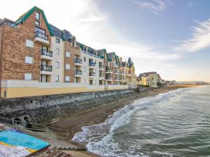 a row of buildings on a beach next to the water at Apartment Les Flots-2 by Interhome in Trouville-sur-Mer