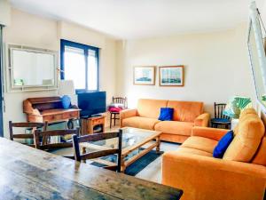 salon z pomarańczowymi meblami i stołem w obiekcie Apartment Les Flots-2 by Interhome w mieście Trouville-sur-Mer