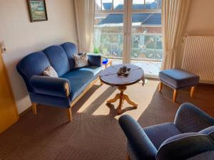 ノルトダイヒにあるApartment Dehne-3 by Interhomeのリビングルーム(青いソファ、椅子、テーブル付)