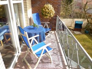 two blue chairs and a table on a balcony at Apartment Dehne-3 by Interhome in Norddeich