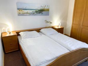 ノルトダイヒにあるApartment Dehne-3 by Interhomeのベッドルーム1室(ベッド2台付)、サイドに2つの照明が備わります。