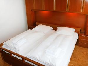 ein Bett mit zwei weißen Kissen darauf in der Unterkunft Apartment Tunnelstrasse-1 by Interhome in Norddeich