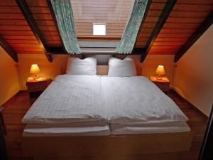 a bed in a room with two lamps on tables at Holiday Home Koralle-1 by Interhome in Norddeich