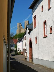 an alley in a town with a castle in the background at Mooi ruim appartement in antieke stadsboerderij in Schönecken
