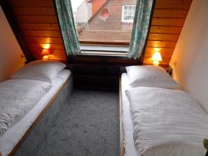 two beds in a small room with a window at Holiday Home Koralle-1 by Interhome in Norddeich