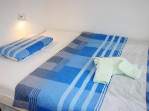 ノルトダイヒにあるApartment Ankerweg-1 by Interhomeの青と白のベッドが備わる客室です。