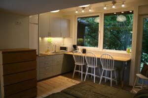 a kitchen with a counter and three stools in it at Lilla Huset på Slätten B&B in Lund