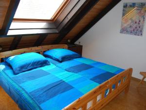 een slaapkamer met een bed met blauwe lakens en een raam bij Holiday Home Müter by Interhome in Norddeich