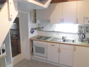 a small kitchen with white cabinets and a sink at Holiday Home Schäfer by Interhome in Norden