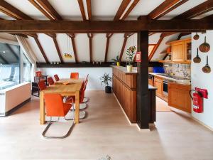 una cocina con mesa de madera y sillas naranjas en Holiday Home Ferienpark Vorauf-4 by Interhome, en Molberting