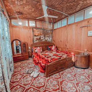 ein Schlafzimmer mit einem großen Bett in einem Zimmer mit einem Teppich in der Unterkunft Lake Palace Group Of House Boats in Srinagar
