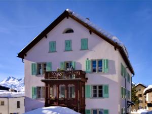 een wit huis met groene luiken en een balkon bij Apartment Chesa Corvatsch by Interhome in Pontresina