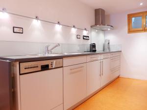 ミュスタイアにあるHoliday Home Ferienhaus Döss by Interhomeの白いキャビネットとシンク付きのキッチン