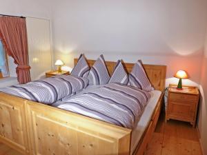 Una cama con almohadas de rayas azules y blancas. en Holiday Home Ferienhaus Döss by Interhome en Müstair