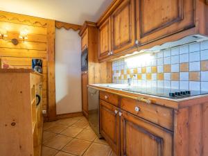 a kitchen with wooden cabinets and a sink at Apartment Ecrin des Neiges - Val Claret-1 by Interhome in Tignes