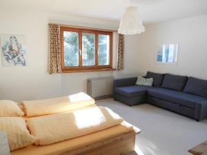ein Wohnzimmer mit einem blauen Sofa in der Unterkunft Chalet Murena by Interhome in Schmitten