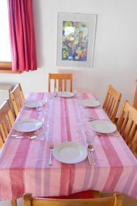 a pink and white table with plates and glasses on it at Chalet Murena by Interhome in Schmitten