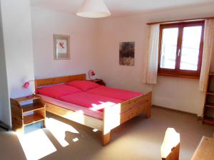 a bedroom with a large red bed in a room at Chalet Haus Murena by Interhome in Schmitten +12 photos