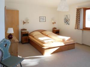ein Schlafzimmer mit einem Bett und einem Stuhl darin in der Unterkunft Chalet Murena by Interhome in Schmitten