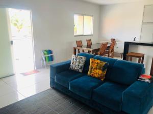 a blue couch in a living room with a table at Casa da Mari in Caldas Novas