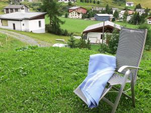 a chair sitting in the grass in a field at Apartment Crap Milan by Interhome in Bivio