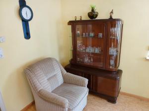um quarto com uma cadeira, um armário e um relógio em Apartment Bless by Interhome em Schutterzell
