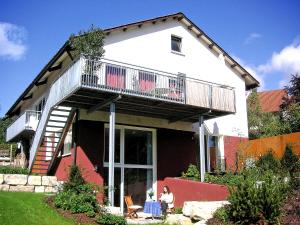 a woman sitting on a chair in front of a house at Apartment Rosengarten by Interhome in Sterneck
