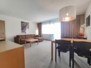 a living room with a couch and a table and chairs at Apartment Allod Park Haus C 505 by Interhome in Davos