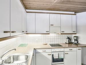 uma cozinha com armários brancos e um lavatório em Apartment Chalet Abendrot-25 by Interhome em Grindelwald