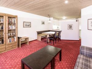 um quarto com uma mesa e cadeiras e uma estante de livros em Apartment Chalet Abendrot-25 by Interhome em Grindelwald