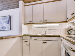 a kitchen with white cabinets and a sink at Apartment Chalet Abendrot-29 by Interhome in Grindelwald