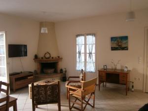 sala de estar con mesa, sillas y TV en Theo Studios & Apartments, en Spetses