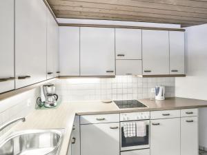 una cocina con armarios blancos y fregadero en Apartment Chalet Abendrot-26 by Interhome, en Grindelwald