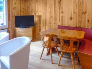 a dining room with a table and a tv at Apartment Chalet Anna by Interhome in Grindelwald
