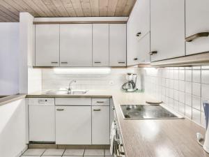 una cocina con armarios blancos y fregadero en Apartment Chalet Abendrot-26 by Interhome, en Grindelwald