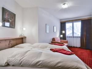 a hotel room with two beds and a chair at Apartment Chalet Abendrot apARTments-26 by Interhome in Grindelwald