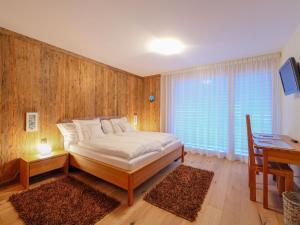a bedroom with a bed and a table and a desk at Apartment Rütschi-7 by Interhome in Zermatt
