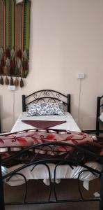 a bedroom with a bed with a metal frame at Happy Bedouin House Petra in Al Ḩayy