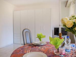 a dining room table with a vase of flowers on it at Apartment Residenza Lido Appartment 008 by Interhome in Locarno +17 photos