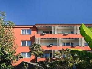 ein orangefarbenes Gebäude mit Bäumen davor in der Unterkunft Apartment Double Room-2 by Interhome in Ascona