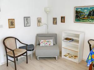 ein Wohnzimmer mit einem Stuhl und einem Stuhl in der Unterkunft Apartment Corallo - Utoring-1 by Interhome in Ascona